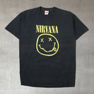 vintage 2000s nirvana grunge band t shirt featuring the iconic smiley logo and flower sniffin' back graphic on sun faded cotton