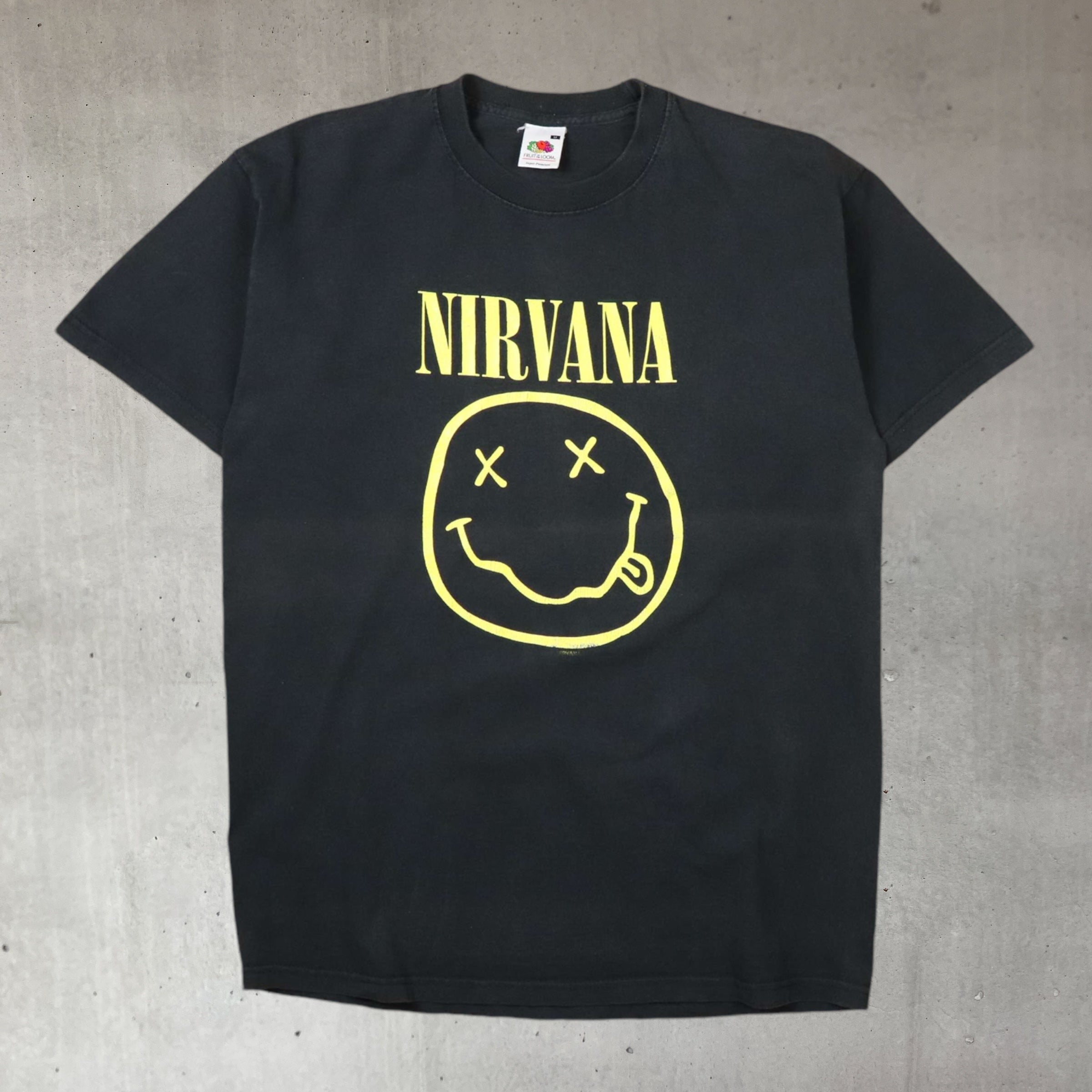 vintage 2000s nirvana grunge band t shirt featuring the iconic smiley logo and flower sniffin' back graphic on sun faded cotton